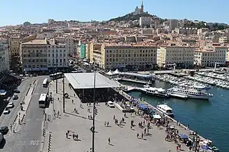 Le quai, l'ombrière du Vieux-Port et la «&nbsp;Bonne Mère&nbsp;» qui domine la ville.