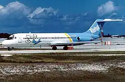 Photo de trois quart face du côté gauche d'un avion de ligne aux couleurs blanches à l'avant et bleues à l'arrière, roulant sur un aéroport.