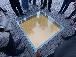 Les visiteurs regardent à travers le verre la bibliothèque souterraine.