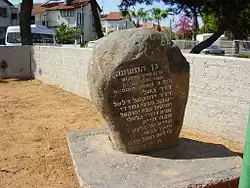 Photo d'un rocher avec une plaque gravée incrustée