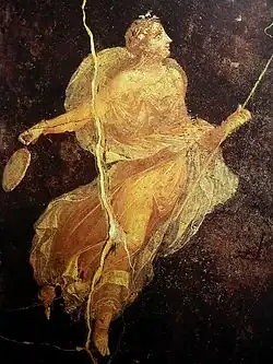 fresque : Sur fond brun sombre, une jeune femme lumineuse danse, tenant un thyrse