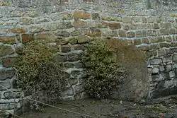 Le menhir de Men Rouz, malheureusement en partie sous les remblais d'un parking et incrusté dans un mur de soutènement