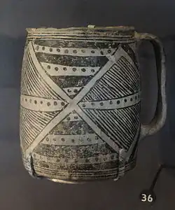 Une photo couleur d'un récipient en poterie noir sur blanc