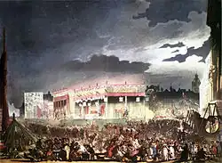 Rues remplies par une foule de badauds, bâtiments illuminés.
