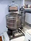 Machine de 1930 dotée d'un moteur électrique et d'une cuve métallique.