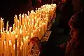 Un enfant déposant un cierge à la cathédrale de Milan en Italie.