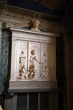 Retable sculpté en marbre. Un triptyque représente sur chacun des volets un adulte avec un bébé à ses pieds.