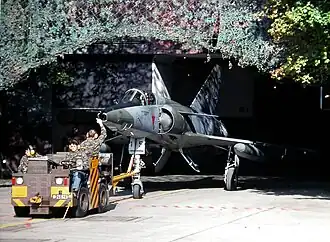 Mirage IIIRS tracté d'une caverne pour avions (en) à Buochs (en) en 1999.