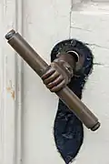 Poignée de porte ornée d'une main tenant un battant de maréchal sur une église morave à Bethlehem, Pennsylvanie.