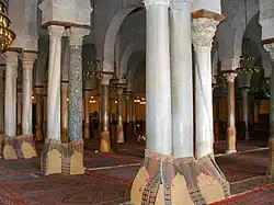 Salle de prière de la grande mosquée de Kairouan, IXe&nbsp;siècle. Les nombreuses colonnes en marbres de diverses couleurs avec leurs chapiteaux sont des réemploies directs de sites antiques romains mais aussi byzantins.