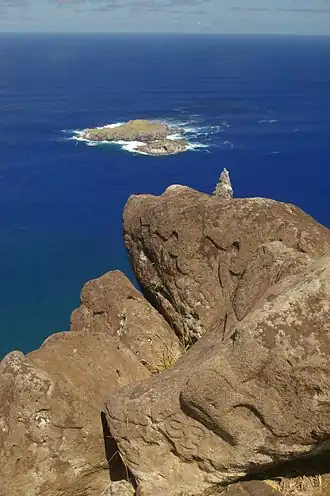Photographie de Motu-Nui depuis la falaise d'Orongo. Pétroglyphes au premier plan.