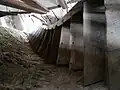 Escalier d'accès au premier étage vu du dessus, constitué de planches mises en forme sur l’arbre.
