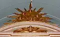 Fronton courbe et gloire couronnant le retable.