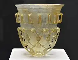 Un gobelet en verre romain de la seconde moitié du IVe&nbsp;siècle, trouvée à Cologne, en Allemagne et conservée à la Staatliche Antikensammlung. Ce type de gobelet est dit diatret. Il n'en existe plus qu'une cinquantaine, généralement brisés. On peut lire en haut du gobelet Bibe multis annis (Bois et tu vivra des années).