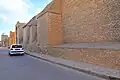 Mur et contreforts à toit en pente, faits d'assises de briques, de l'extrémité nord de la façade orientale de la mosquée.