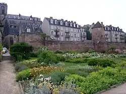 Vue générale d'un jardin et à l'arrière-plan une muraille et des bâtiments