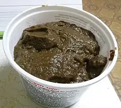 Homemade mushroom ketchup in a plastic tub