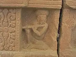 Un détail du piédestal de Mỹ Sơn E1 montre un flutiste jouant de son instrument.
