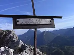 Petit croix métallique avec l'inscription « 11.9.1977 - Au Néron, débonnaire, mais redoutable » et des initiales.