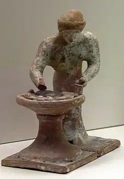 Femme pétrissant de la pâte à pain, début Ve&nbsp;siècle&nbsp;av. J.-C. Musée national archéologique d'Athènes.