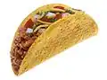 Un taco typique de la cuisine tex-mex, originaire des États-Unis, constitué d'une tortilla rigide&nbsp;(en) garnie avec du cheddar et de la viande hachée.