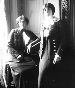 Image en noir et blanc de deux femmes, l'une assise l'autre debout.