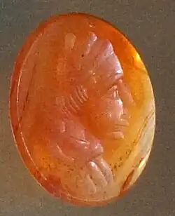 Tête d'un homme sur une pâte de verre orange.