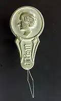 Enfile-aiguille embossé d'une personne de profil.