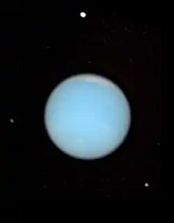 Photo de Neptune entourée de quatre de ses lunes, visibles en blanc.