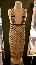 Robe en filet. Faïence, perles cylindriques bleues et noires, 2 bonnets de poitrine et 2 rangs de perles Mitra. Ve dynastie. Petrie Museum
