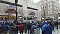 Une foule assistant au passage des bus des joueurs sous une fine neige.