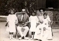 Photographie en noir et blanc montrant un couple assis avec trois filles vêtues de blanc.