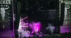 Cinq membres d'un groupe de rock jouant sur une scène du Wacken Open Air