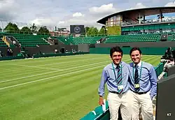 Deux arbitres posant devant le Court numéro trois