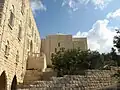 La façade sud de l'église et une partie de son clocher (au centre), la structure du monastère (à gauche)
