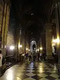 Bas-côté voûté d'ogive parcouru par des touristes
