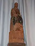 Statue en bois de la sainte Vierge et d'un écarteur blessé.