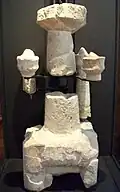 Plusieurs morceaux assemblés d'une sculpture avec trois piliers apparents.