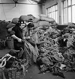 Photographie ancienne en noir et blanc montrant des femmes découpant des tissus.