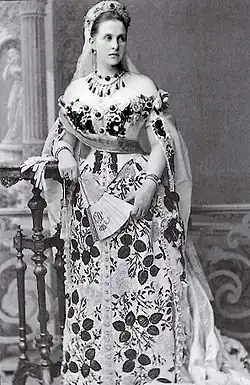 Portrait d'une femme portant une longue robe fleurie.