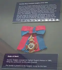 La croix et le ruban d'une décoration exposés dans une vitrine.