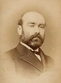 Portrait d'un homme chauve et barbu.