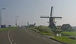 Le moulin (de Vrouw Vennemolen) avec au fond l'église catholique