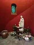 Statue et bougies dans une abside.