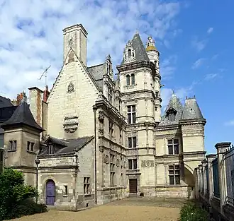 Photographie d'un logis Renaissance en tuffeau, une cour au premier-plan.