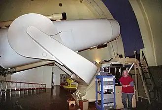 L'astronome Jean Mueller posant avec le télescope de Schmidt Samuel-Oschin.