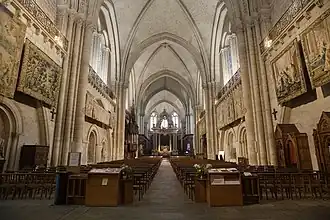  Photographie d'une nef de cathédrale et des tapisseries accrochées.