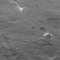 Vue d'ensemble de la montagne entourée par un terrain légèrement cratérisé.