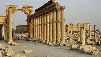 Arc triomphal et rue à colonnades