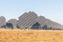 Plusieurs panneaux photovoltaïques inclinés en direction du soleil.